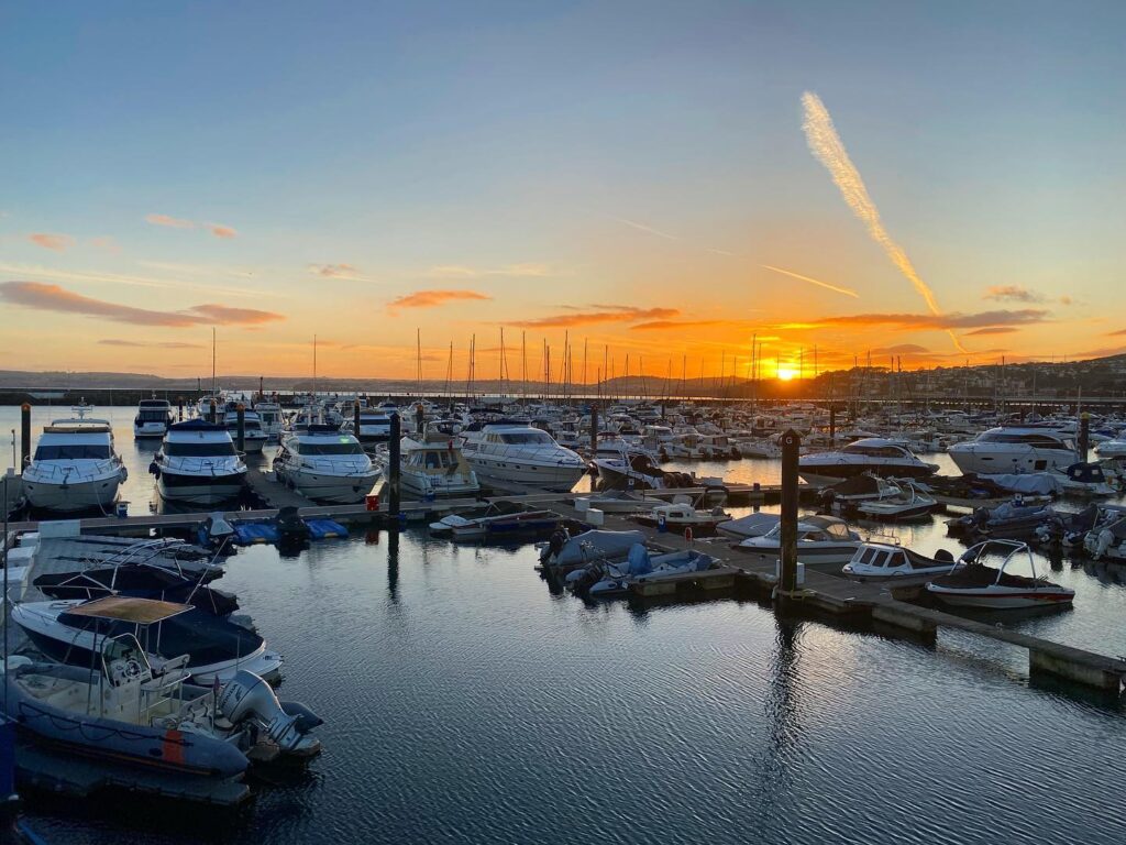 Sunset over MDL Marina with boats and yachts docked, reflecting on calm water