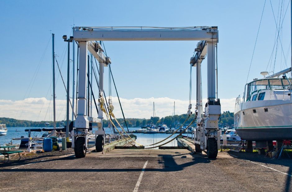 Boat hoist at a marina boatyard ready to lift yachts for seasonal maintenance. Seasonal Rush
