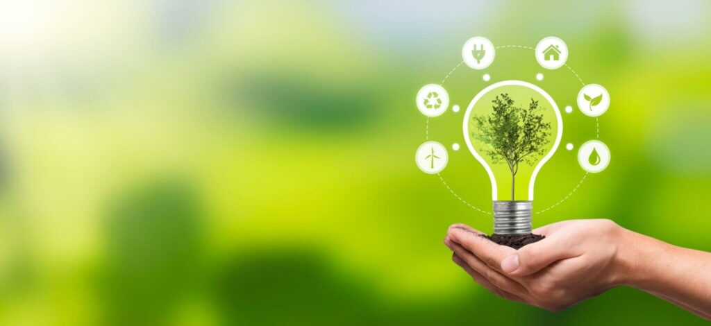 Hands holding soil with a lightbulb-shaped tree symbolising sustainable holiday parks.