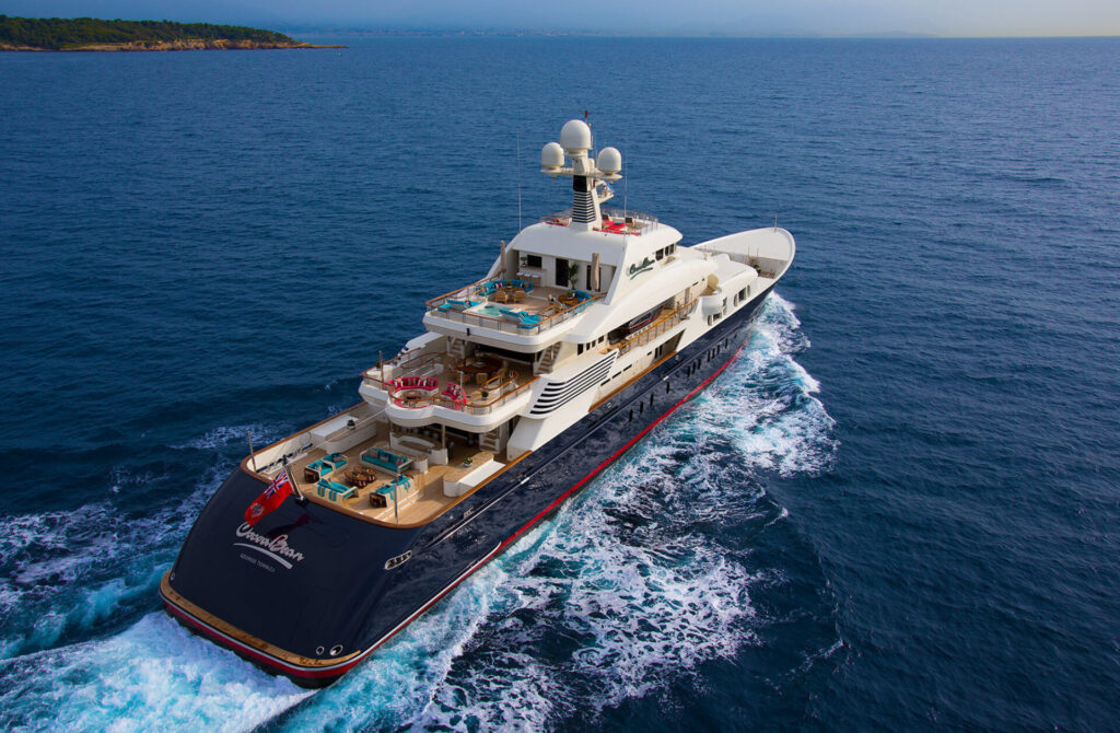Luxury superyacht stewardess cruising through the Mediterranean Sea with multiple decks and onboard leisure areas.