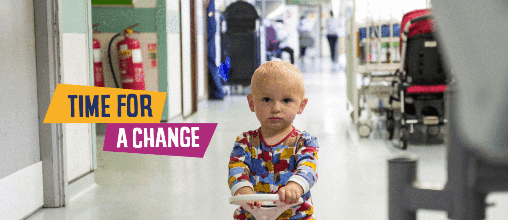 Young child in St George’s Hospital Charity corridor with text overlay reading ‘Time for a Change.