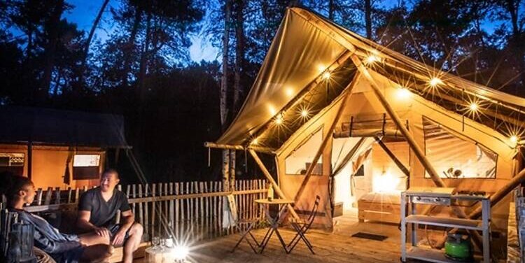Luxury glamping tent with string lights and outdoor seating, showing growing popularity of glamping holidays.