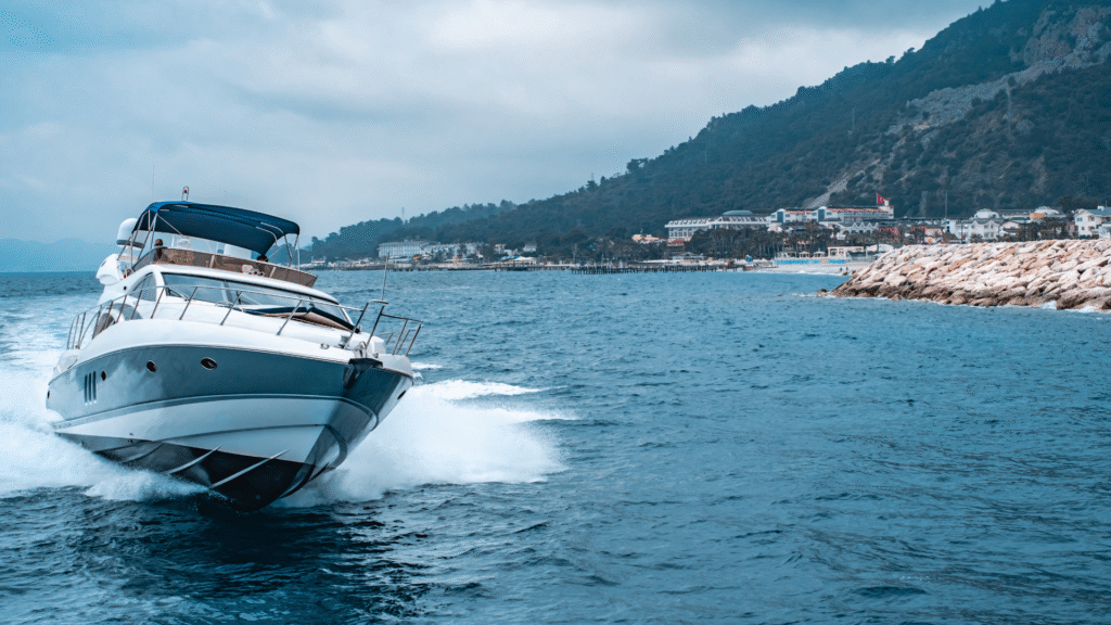 Luxury yacht cruising near marina coast, representing mobile boat broker software for sales.